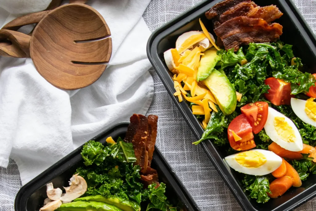 Lecker und gesund gefüllte Meal Prep Boxen liegen frisch zubereitet auf einem Tisch.