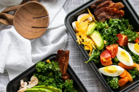 Lecker und gesund gefüllte Meal Prep Boxen liegen frisch zubereitet auf einem Tisch.